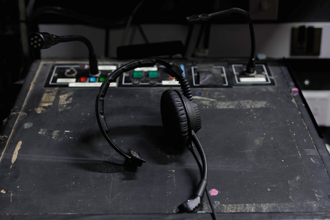 A headset placed on top of a stage manager's desk